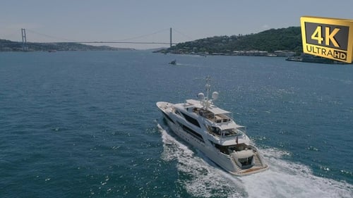 Luxury Yacht Cruises on Water Under Distant Bridge