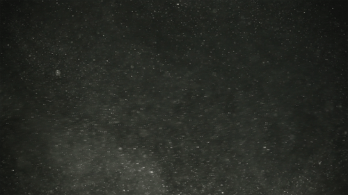 Abstract Shimmering Particles on Dark Background