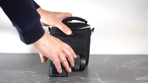 Camera Placed into Camera Bag on Table