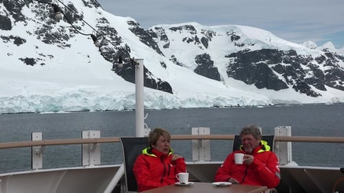 Adults on Deck with Snowy Mountain View