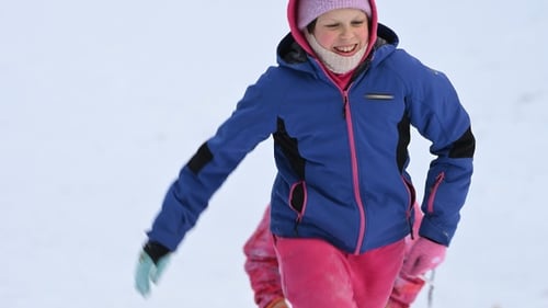 Happy children run and play outdoors with sleds on a snowy hill in winter. Slow motion
