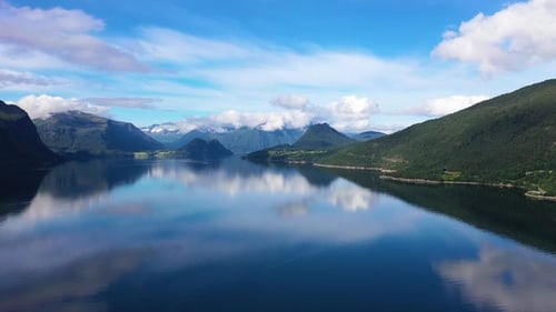 Stunning aerial view of a Norwegian fjord with mountains and reflections at midday