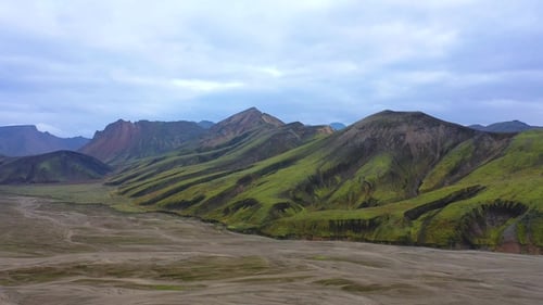 Mountain view in Iceland with river and rocky hills during cloudy weather