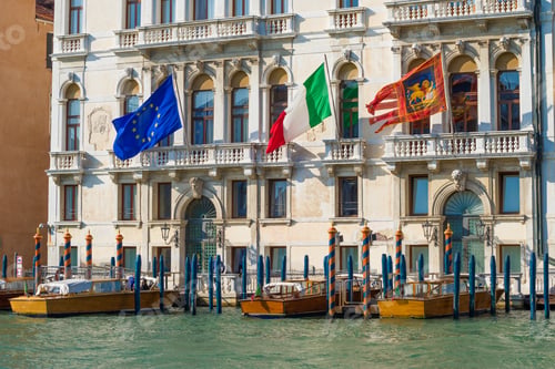 Preview: Flags Of The European Union, Italy And Venice On The Facade Of An Old Building On A Sunny Day