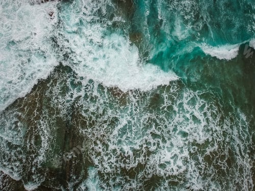 Preview: Aerial View Of Ocean Waves And Brown Rocks In The Coastline