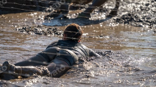 Preview: Sexy Female Athlete Crawling Under Barbed Wire At An Obstacle Course Race