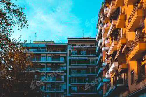 Preview: Orange And Blue Colored Apartment Complex With Trees On The Side