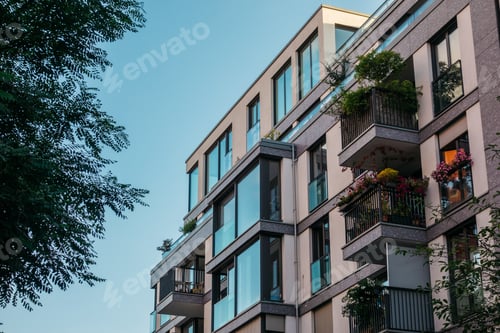 Preview: Detailed View Of Modern Apartment Building Next To An Green Tree
