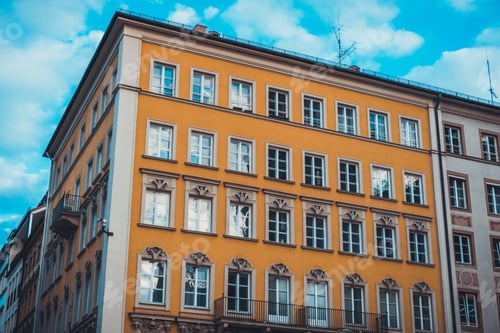 Preview: Low Angle Architectural View Of Modern Low Rise Building With Yellow Exterior And Blue Sky With