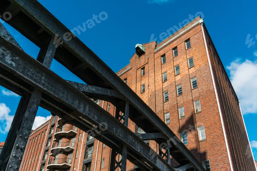 Preview: Large Steel Bridge In Foreground Near Old Warehouse Under Deep Blue Sky With Copy Space