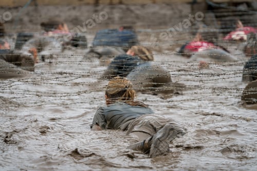 Preview: A Woman Crawling Under Barbed Wire At A Mud Run