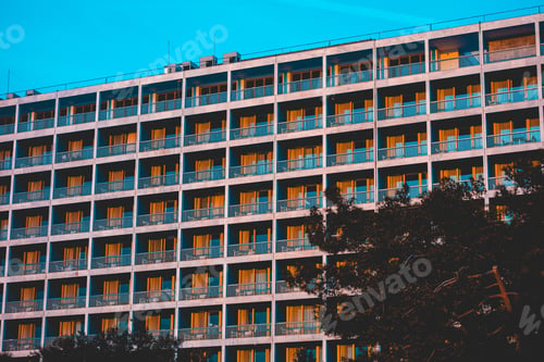 Preview: A Large, Multiple Story Hotel Apartment Building Overlooking Trees And Parkland.