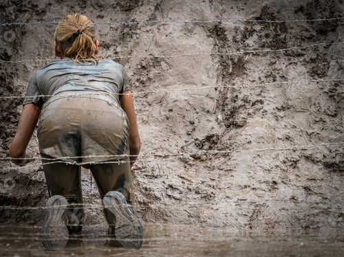 Preview: Woman Crawling Below Barbed Wire In Mud