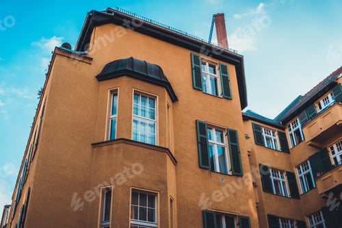 Preview: Low Angle View On Small Brown Residential Apartment Complex With Chimney, Bay Windows And Shutters
