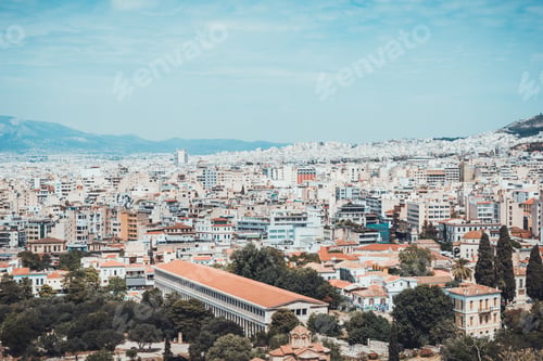 Preview: Birds Eye View Of Large City With Crowded High Rises And Mountains In Background In Greece