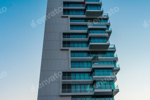 Preview: Modern Hotel Building Concept With Many Balconies And Windows From One Side, And Concrete Wall, Low