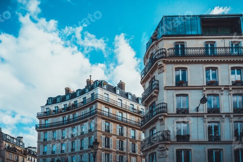 Preview: Tall Apartments With Curved Exterior Walls And Double Pitched Roofs With Blue Sky And White Clouds