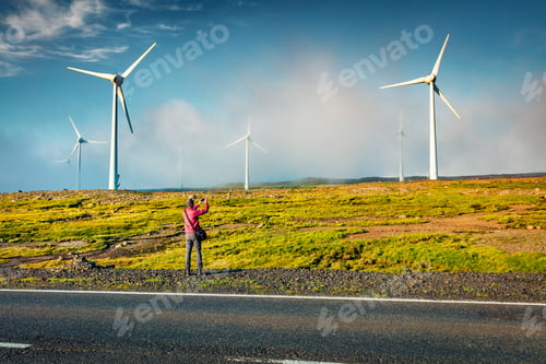 Preview: Tourist Takes A Picture Of Wind Turbines In The Morning Fog. Fantastic Summer View Of Faroe
