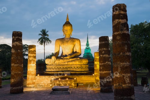 Vista previa: Sculpture Of The Sitting Buddha In Night Illumination Against The Background Of The Cloudy Evening