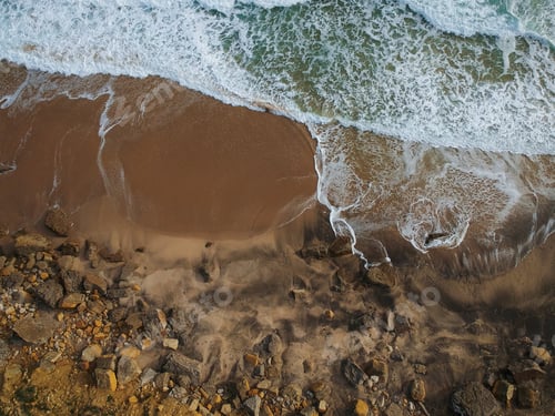 Preview: Top View Of A Beautiful Sandy Beach Aerial Shot With The Waves Rolling Into The Shore, Some Rocks