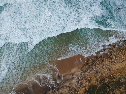 Preview: Top View Of A Beautiful Sandy Beach Aerial Shot With The Waves Rolling Into The Shore, Some Rocks