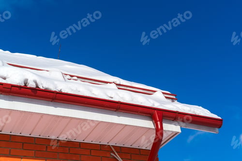 Preview: The Roof Of A Red Brick House With A Spillway System Covered With Snow After A Heavy Snowfall In