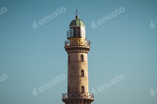 Preview: Exterior View Of Old Tall Lighthouse Beacon With Historic Facade Centered In Blue Sky
