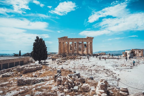 Preview: Ancient Classical Greek Landmark With Unearthed Blocks And Other Ancient Objects With Tourists