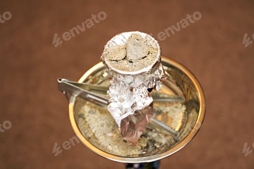 Preview: Burn Charcoal With Tongs For Hooka On The Brown Background