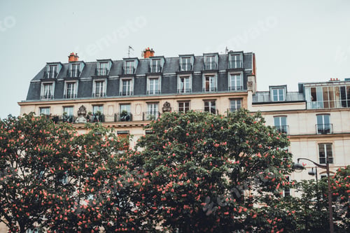Preview: Old Apartment With Stacked Dormer Windows On Upper Level Roof Section With Trees In Foreground