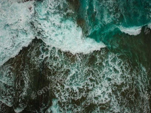 Preview: Aerial View Of Ocean Waves And Brown Rocks In The Coastline