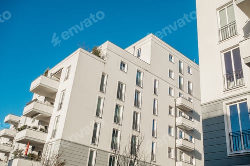 Vorschau: Großer weißer Apartmentkomplex mit dunklem Himmel