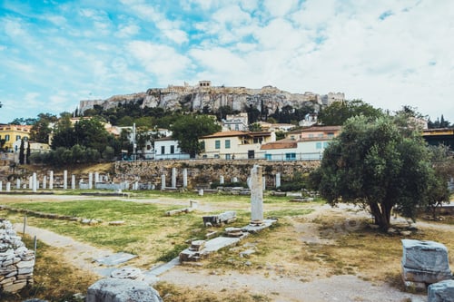 Preview: Ancient Ruins Comprised Of Old Stones And Partially Broken Columns Beneath Buildings On Hill