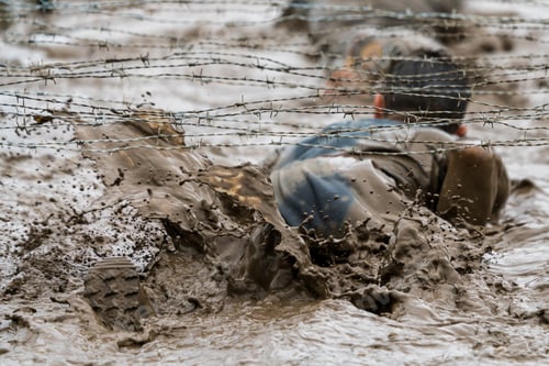 Challenging Mud Obstacle Course Involving Barbed Wire