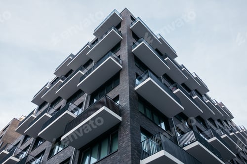 Preview: Modern Corner Building In Low Angle View With Brick Facade In Darken Colors