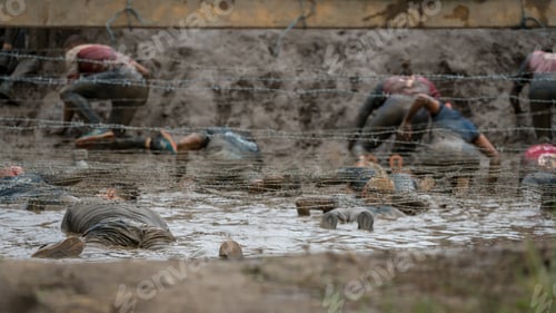 Preview: People Crawling In Mud Under Barbed Wire At An Obstacle Course Race