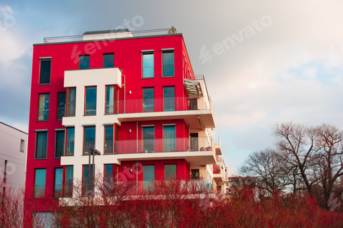 Preview: Red And White Colored Apartment Building On A Cloudy Day
