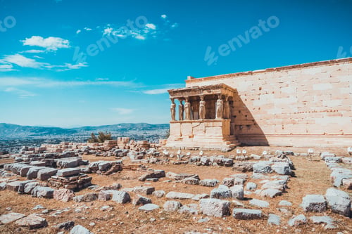 Preview: Scenic View Of Greek Ruins Surrounded By Large Cut Stones With Mountains In The Background