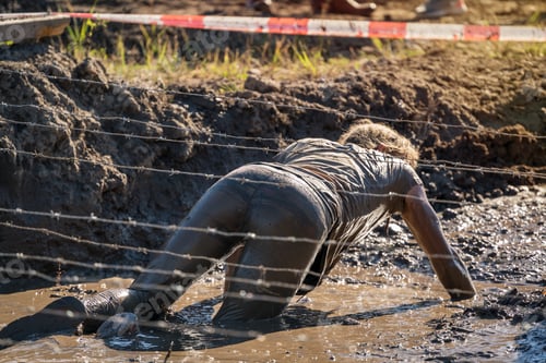 Preview: Female Athlete Crawling Under Barbed Wire At An Obstacle Course Race