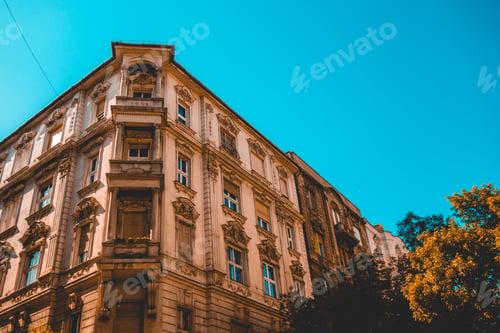 Preview: Ancient Corner Apartment Building With Small Tree On The Side And Clean Sky For Copy Space Text