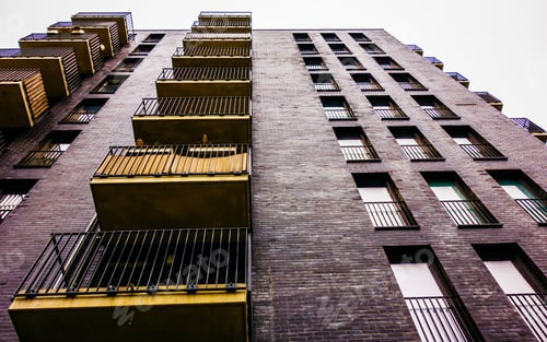 Preview: Darken Brick Building With Yellow Balcony