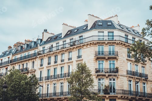 Preview: Beautiful Chateaux Styled Apartment Buildings With Ornate Metal Gates Under Cloudy Sky