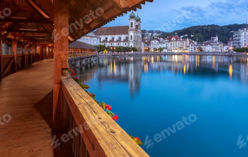 Preview: Scenic View Of The Church, The Wooden Kapellbrucke Bridge In The Light Of The Lanterns At Sunrise
