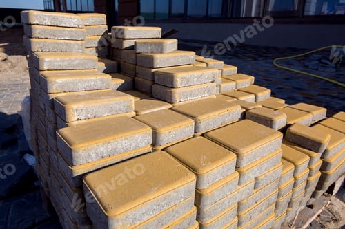 Preview: New Yellow Paving Slabs Folded In A Pile One On Top Of Another On A Sunny Day, Side View Close Up.