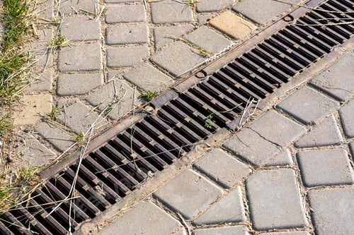 Preview: Iron Lattice Stormwater On A Pedestrian Sidewalk Of Paving Slabs Close Up On A Sunny Day.