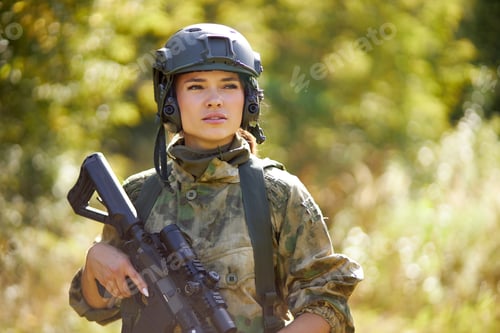 Preview: Woman in camouflage with weapon standing in nature