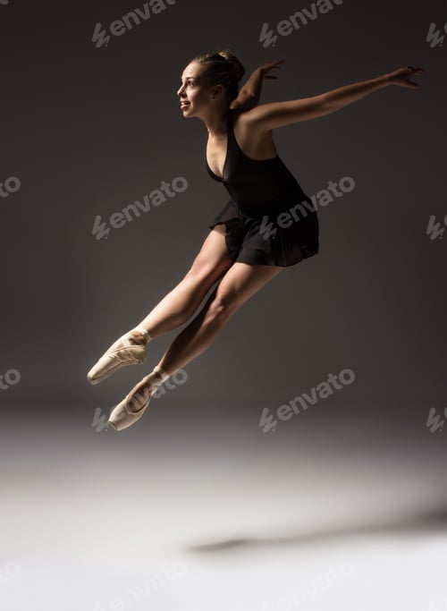 Preview: Beautiful Young Female Classical Ballet Dancer On Pointe Shoes Wearing A Black Leotard And Skirt On