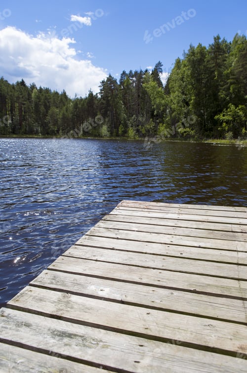 Preview: Wooden Pier At The Lake On A Beautiful Summer Day In Finland. Blue Sky With Some Clouds, Vivid