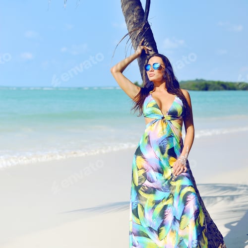 Preview: Beautiful Elegant Woman Posing Near Palm Tree On A Beach
