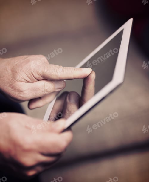 Preview: An Elderly Man Browsing The Internet With A Tablet In A Living Room And Sitting In A Sofa. Image